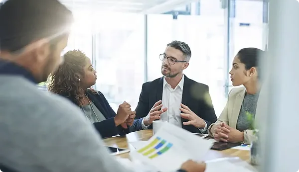 Team of professionals reviewing charts around a meeting table
